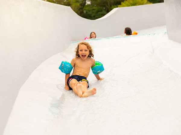 Enfant sur tobbogan aquatique au camping Médoc Océan